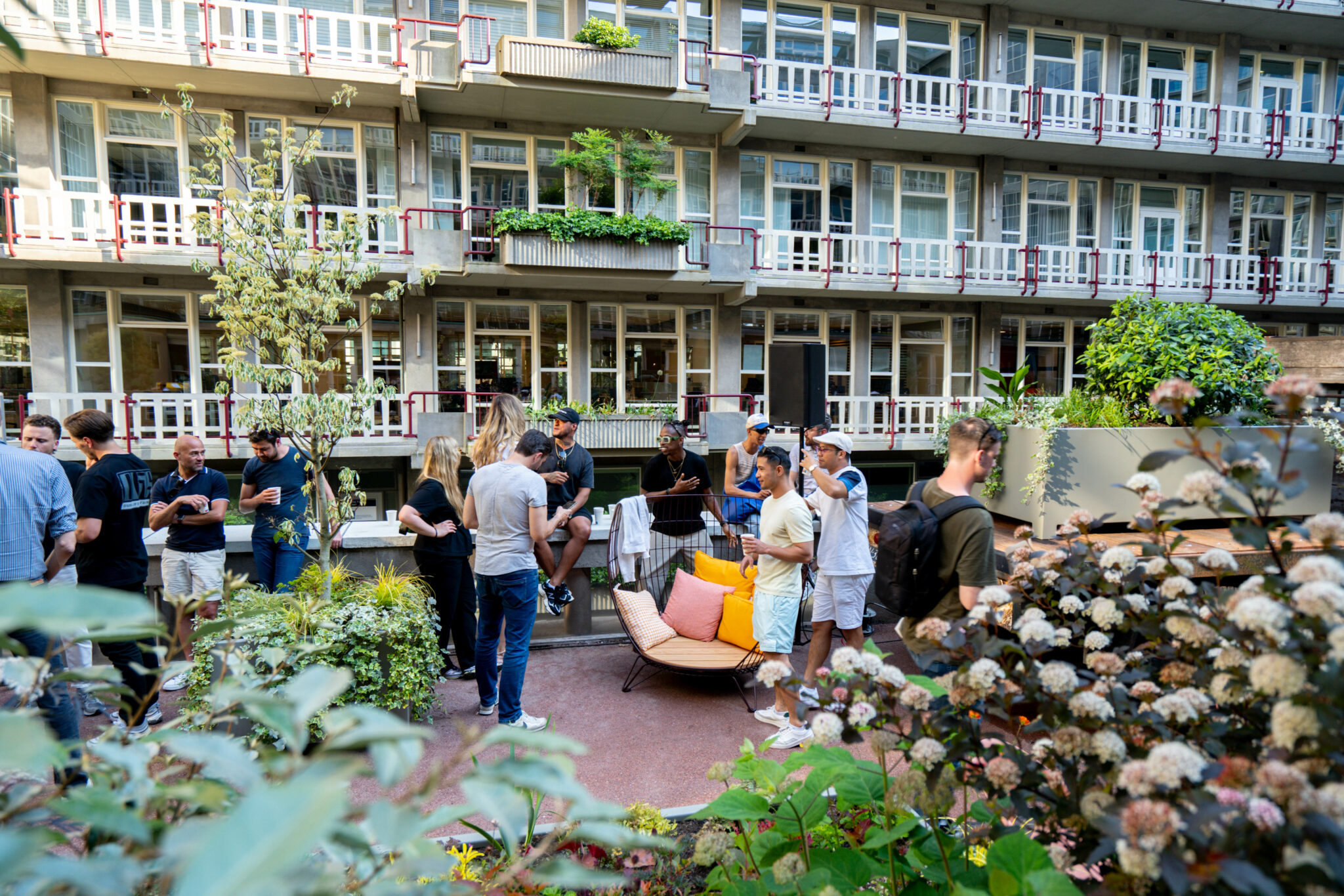 Medewerkers lunchen in de door Blooming Buildings aangelegde kantoortuin vol diverse soorten planten en bloemen.